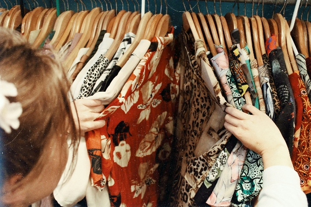 Woman looking through rails of clothes 