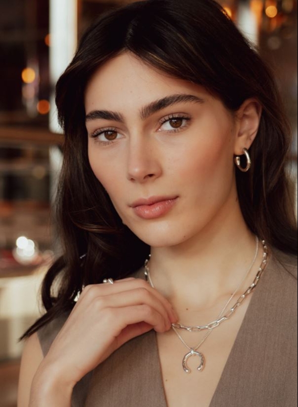 model in beige top with wishbone necklace