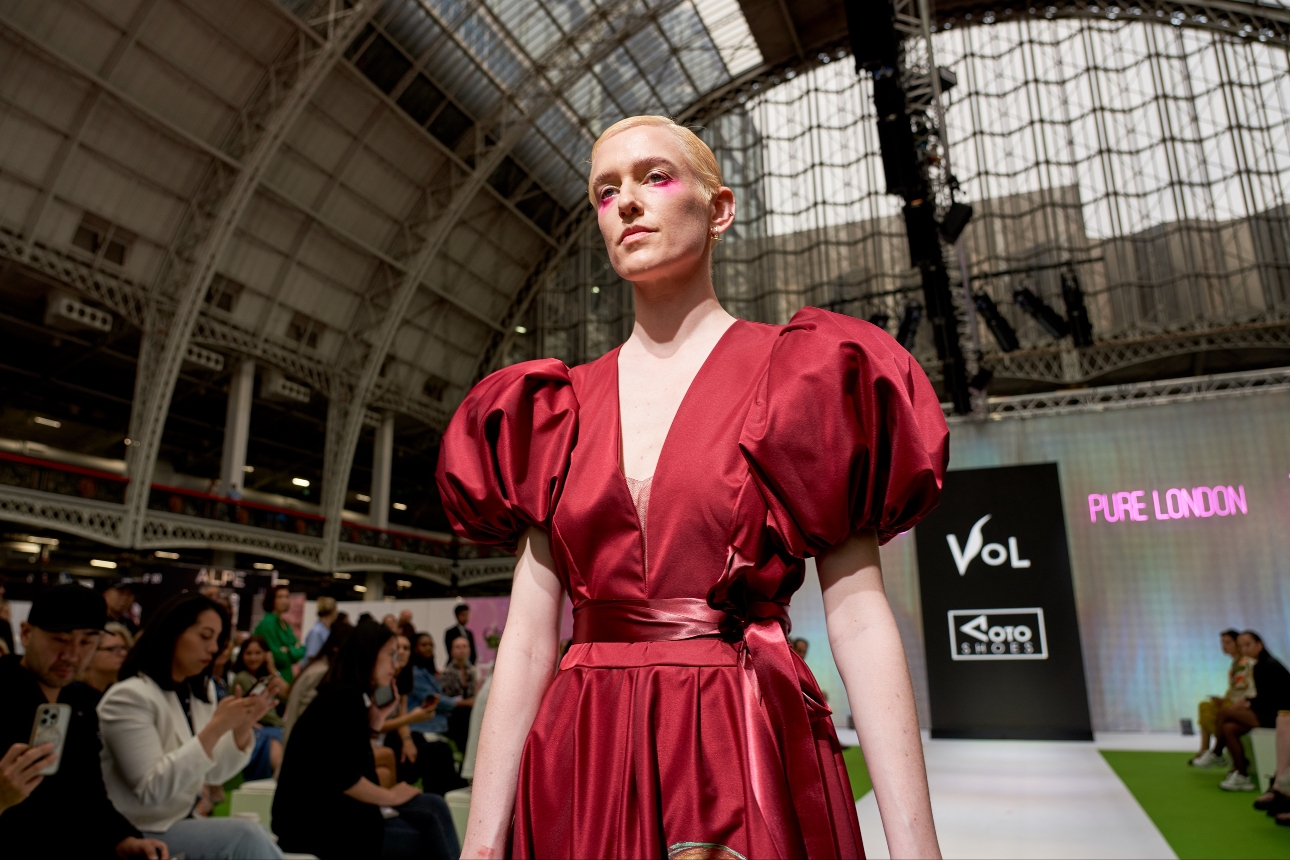 model in dark red satin dress on catwalk